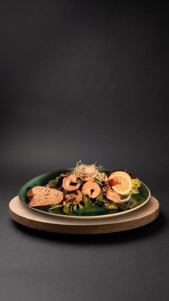 Aura Living Salat auf einer Eichenplatte vor dunklem Hintergrund
