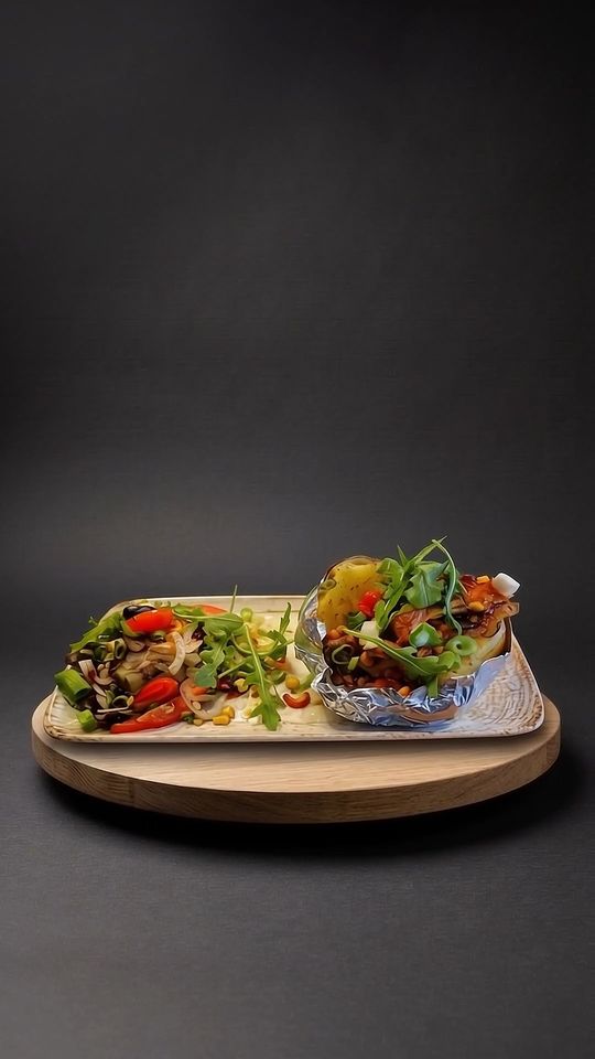 Baked Potato mit Salat auf einer Eichenplatte vor dunklem Hintergrund