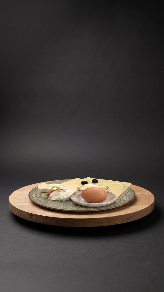 Käsefrühstück auf einer Eichenplatte vor dunklem Hintergrund