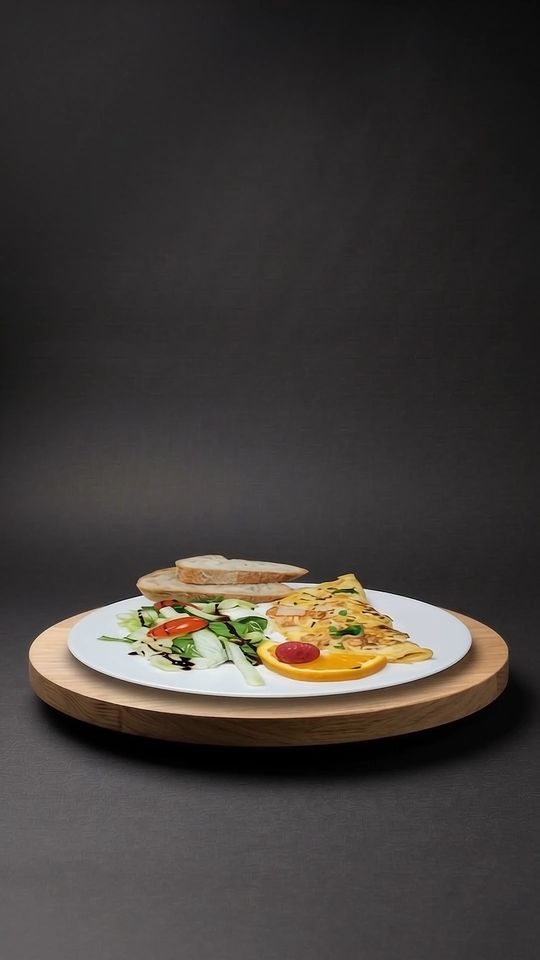 Omelett mit Brot und Salat auf einer Eichenplatte vor dunklem Hintergrund