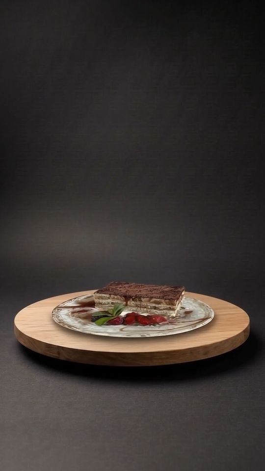 Schichttorte auf einer Eichenplatte vor dunklem Hintergrund
